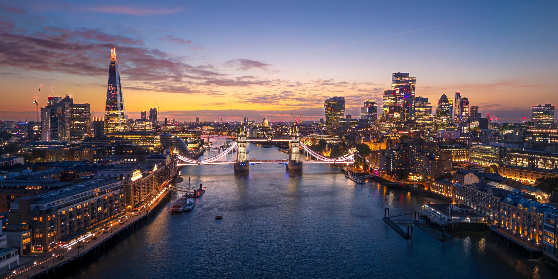 Aerial panoramic view of a city skyline at twilight over the water