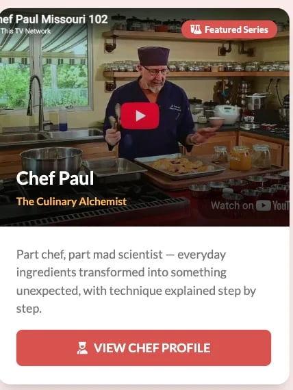 Chef Paul in kitchen wearing black chef jacket and burgundy hat